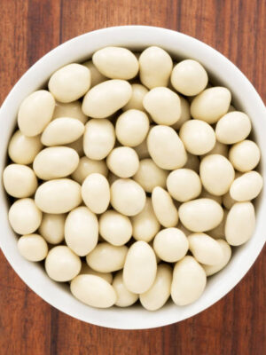 Top view of white bowl full of white chocolate covered peanuts