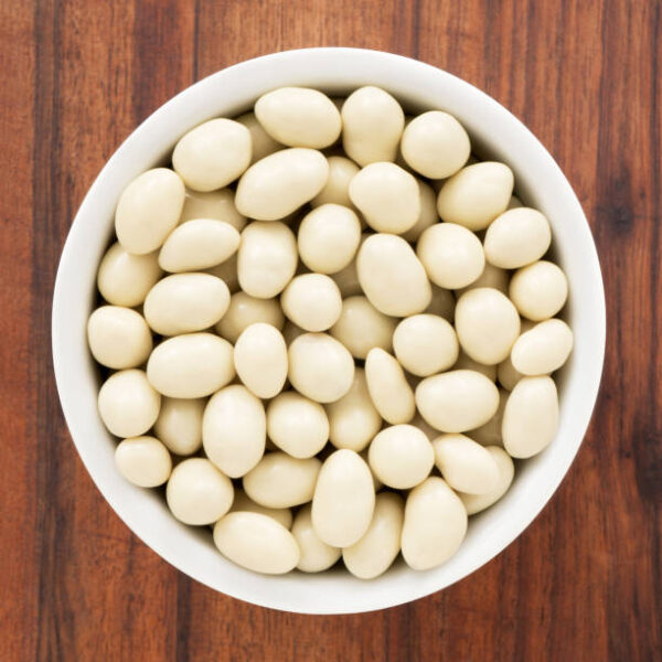 Top view of white bowl full of white chocolate covered peanuts