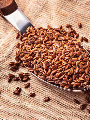 Healthy food. flax seeds linseed on kitchen spoon burlap sack background