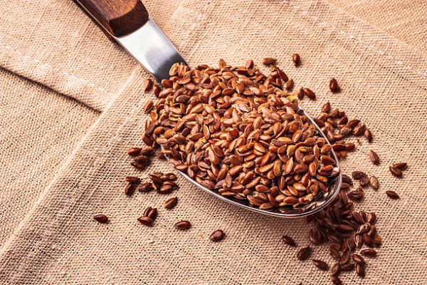 Healthy food. flax seeds linseed on kitchen spoon burlap sack background